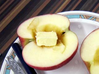 半切りしたリンゴの芯をくりぬき、バターをいれる。
